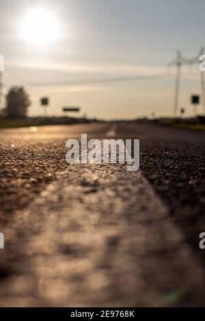 A long white stripe, like a road marker. A road into the distance between fields and forests. High quality photo Stock Photo