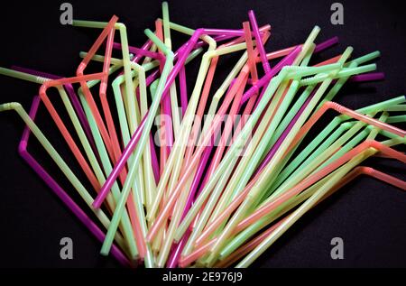 Fun colored straws to drink cocktails, juices, soft drinks at parties isolated on black background Stock Photo