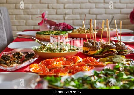 Laid festive table with butterbrods with red and black caviar, salads and hot snacks Stock Photo