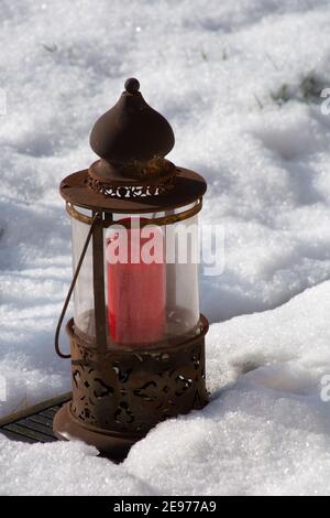 sunny winter scene with white snow covered rusty lantern on terrace Stock Photo
