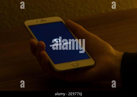 A woman launches the Amazon Alexa app from her iPhone on Feb 2, 2021. Amazon Alexa, also known simply as Alexa, is a virtual assistant AI technology. Stock Photo