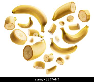 Whole and cut bananas in the shape of a heart on a white background Stock Photo