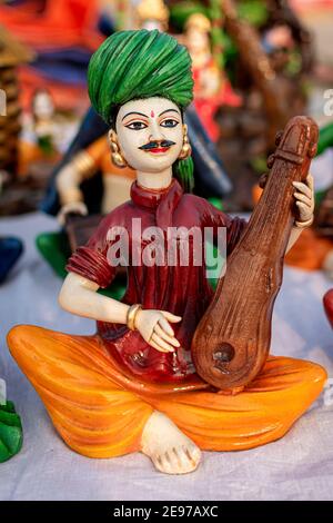 Beautiful handmade dolls of miniature folk musicians performing in a band of classical Indian music is displayed in a shop for sale. Indian handicraft Stock Photo