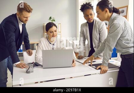 Digital marketing team using laptop and discussing customer focused social media content Stock Photo