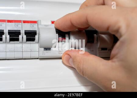 A closeup of an electrical engineer working in a power electrical panel in apartment building. Check the parameters of the power plant. Stock Photo