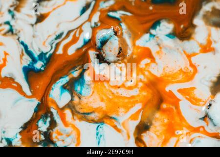 Luqiud vivid orange and blue color mixing together on white background