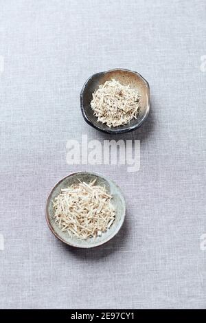 Dry Siberian ginseng (Eleutherococcus senticosus) on linen background. Copy space. Stock Photo