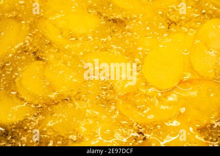 Close-up of sliced potatoes frying in olive oil Stock Photo