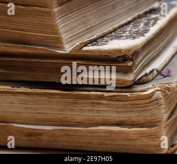 uneven corner of old books with brown textured paper and torn cover Stock Photo