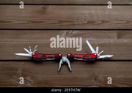 multi-tool, pocket knife on a wooden table Stock Photo
