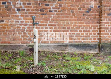 Close up of old brickwork, an old bubbler and an outside garden tap at the 1837-1841 St Peters Anglican church in Richmond, New South Wales, Australia Stock Photo