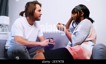 Happy young couple drinking coffee and speaking on the couch. High quality photo Stock Photo