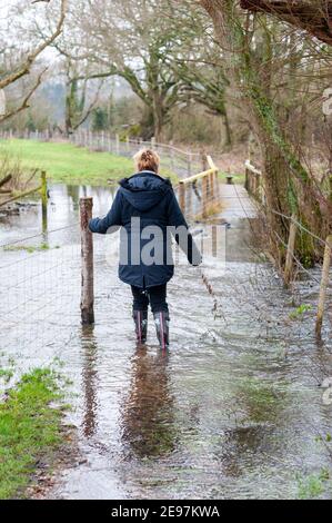 Walking on flooded footpath in wellington boots Stock Photo Alamy