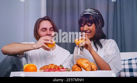 Young couple drinking juice and having breakfast in bed. High quality photo Stock Photo