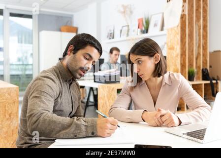 Coworkers chatting seriously in the office Stock Photo
