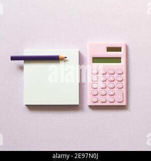 Memo paper, sticky notes and digital calculator with colored pencil on purple background. top view, copy space Stock Photo