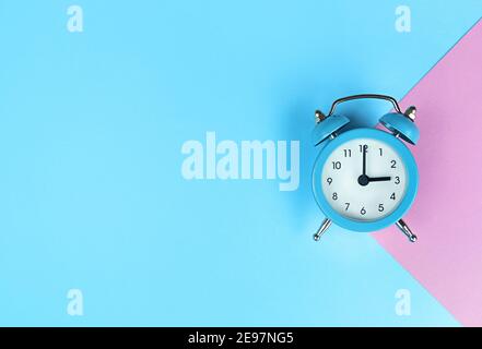 Retro alarm clock on blue background with copy space. Stock Photo