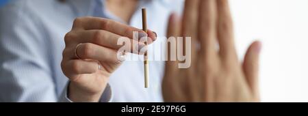 Woman offers cigarette to man who makes negative gesture. Stock Photo