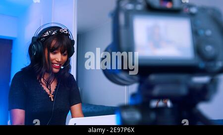 Portrait of young afican american black woman with headset working from home and streaming on social media. High quality photo Stock Photo
