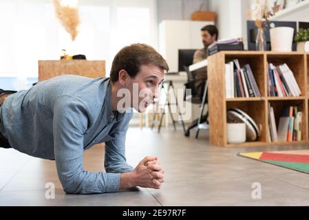 Handsome man having a break to work out in the office. Healthy lifestyle at work concept. Stock Photo