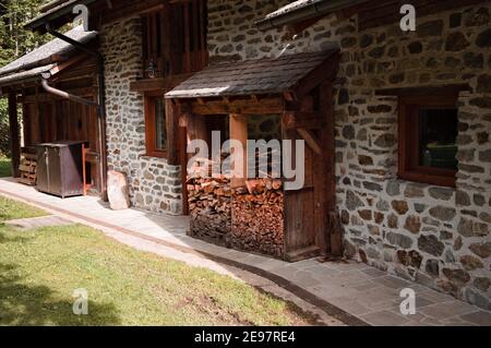 A stone house in the mountains with stacked wood logs (Trentino, Italy, Europe) Stock Photo