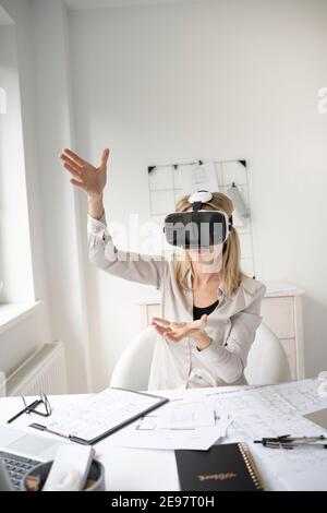 beautiful young female architect with virtual reality goggles in her office Stock Photo