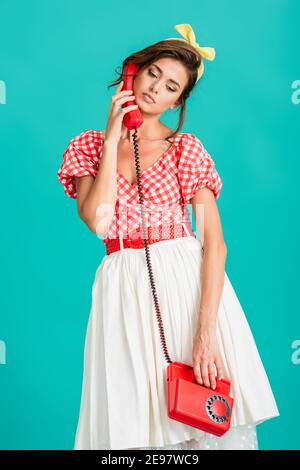 upset pin up woman talking on vintage phone isolated on turquoise Stock Photo