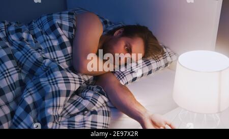 Frustrated caucasian man having sleeping problems. Noisy neighbours problem. High quality photo Stock Photo