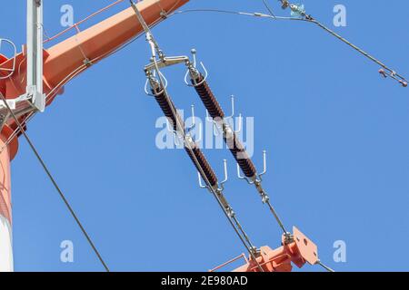 Glass insulators on high-voltage power line poles. Stock Photo