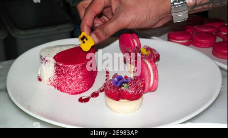 Heart shaped strawberry cake with pink macaroons - cheesecake love desserts - Valentine's Day celebrations Stock Photo
