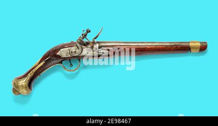 Side view of a single barrel antique wooden flintlock pistol with silver mechanism on a blue background Stock Photo