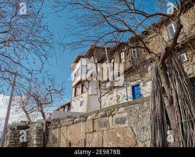 Old town Golyazi. Ancient and magnificent house in front of the lake of uluabat during sunny day. House made of stone and mud as old style. Blue door Stock Photo