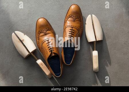 Overhead view of a pair of tan brown leather mens formal shoes on concrete Stock Photo