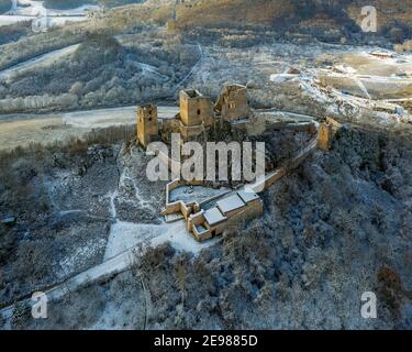 snowy aerial photo about Csesznek castle ruins in Bakony Mountain Hungary. Built was by Jakab Cseszneki in 1263. Amazing historical building ruins. Stock Photo