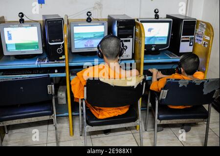 LAO PDR, Vientiane, young buddhist monk in Cybercafe playing games at computer / LAOS Vientiane , junge buddhistische Moenche spielen Computerspiele in einem Internet Cafe Stock Photo