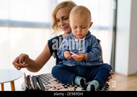 Happy family. Mother and baby daughter plays, hugging, kissing at home Stock Photo