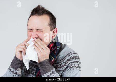 young european man blows his nose in a handkerchief Stock Photo