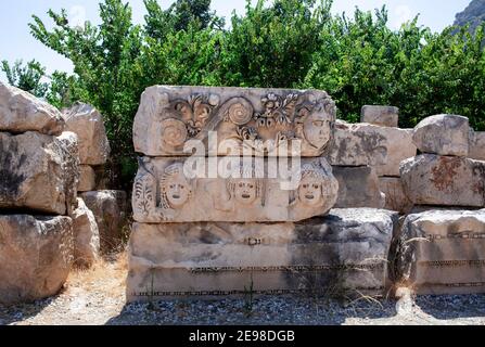 Bas reliefs on the ancient stone. Faces are carved in stone. Myra, Turkey Stock Photo