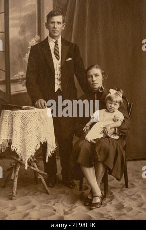 Germany - CIRCA 1930s: A family studio shot of married couple with a child in studio. Vintage art deco era photo Stock Photo
