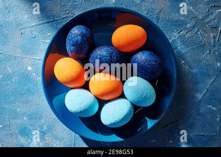 multi-colored chicken eggs in a blue plate. concept easter Stock Photo