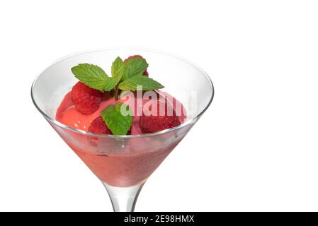 raspberries ice cream sorbet in martini glass with green mint leaves isolated on white, close up, copy space Stock Photo