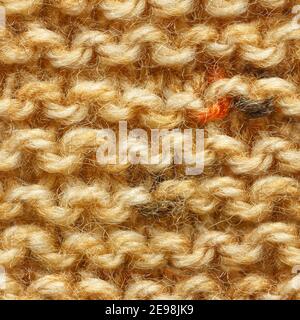 Brown yellow beige color knitted fabric seamless pattern for borderless fill. Knitted fabric repeating pattern for background close up. Stock Photo