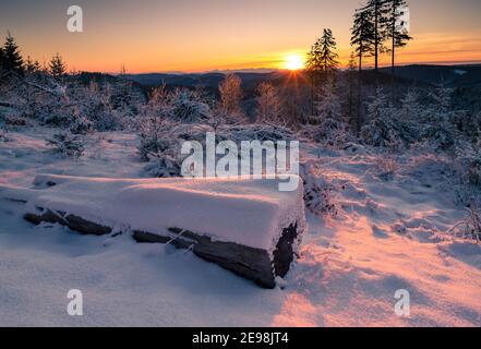 Beautiful winter sunrise in the mountains. Cold morning sun. Sunstar on a distant horizon. New day begins in Beskid  mountains, Czech Republic. Stock Photo