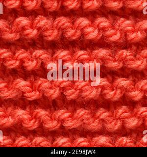 Red knitted fabric seamless pattern for borderless fill. Knitted fabric repeating pattern for background close up. Stock Photo