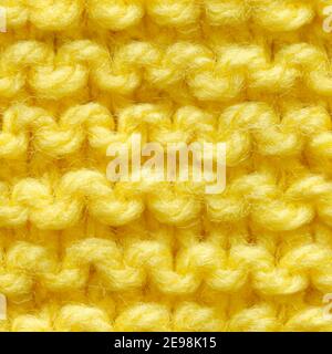 Yellow knitted fabric seamless pattern for borderless fill. Knitted fabric repeating pattern for background close up. Stock Photo