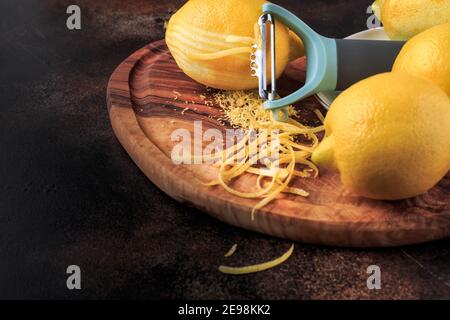 Lemon Zest and Grater on a wooden board on black background. Selective focus. Stock Photo