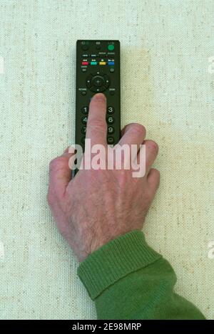 man hand holding TV remote control Stock Photo