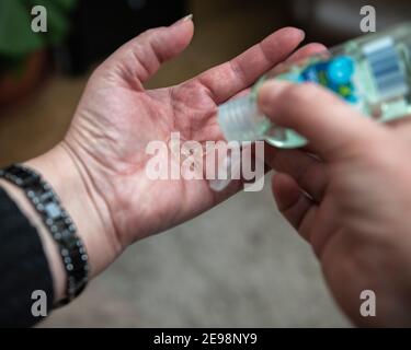 lady applying hand sanding gel to hands during the covid 19 pandemic Stock Photo