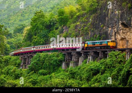 Train running on the death railway River Kwai in Kanchanaburi, Thailand. Stock Photo