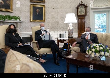 President Joe Biden, center, wears a protective mask while meeting with U.S. Vice President Kamala Harris, left, Senate Majority Leader Chuck Schumer (D-N.Y.), right, and Democratic Senators to discuss the American Rescue Plan in the Oval Office of the White House in Washington on Wednesday, February 3, 2021. (Stefani Reynolds/The New York Times) Stock Photo